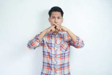 Fototapeta premium angry young boy with X sign with hand over his mouth