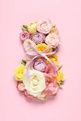 8 March greeting card design made with beautiful flowers on pink background, top view