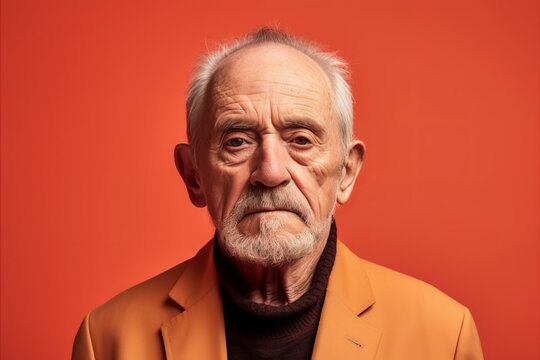 Portrait Of An Elderly Man On A Red Background. Studio Shot.