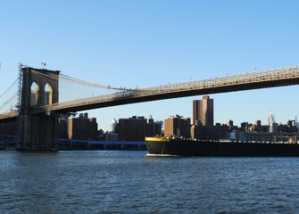Fototapeta na wymiar boat passing the brooklyn bridge