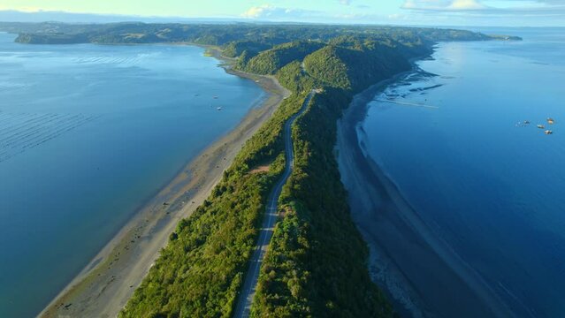 Aerial view following a esker road in middle of water and beaches of Chiloe, Chile