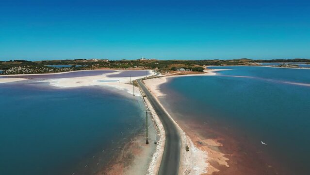drone shot above digby drive on Rotness Island between two salty lakes with pink colors on a summer day, western australia