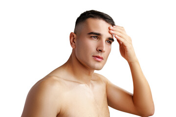 Young man standing shirtless and touching his face with hands