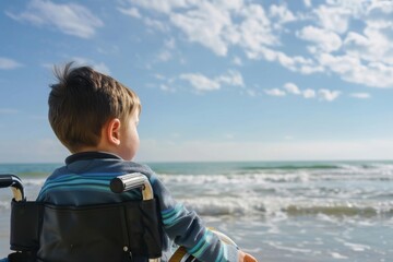 Fototapeta premium Low angle shot of a disabled child looking out at the ocean
