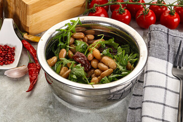 White canned beans with arugula and dry tomatoes