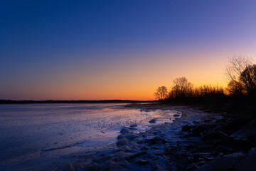 A beautiful winter landscape of frozem lake during the sunrise. Colorful scenery in Northern Europe.