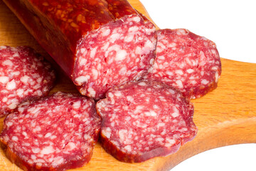 Slices of smoked sausage close-up. Natural meat sausage on a cutting board. Sausage on white background.