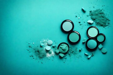 Broken blue turquoise mint cosmetic eye shadows on blue background. Female wallpaper background,...