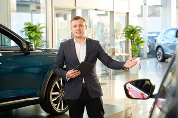 Car sales consultant points to a new car