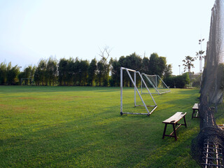 Obraz na płótnie Canvas Sunshine day in a football grass field with soccer goal