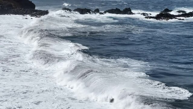 Ocean waves breaking on the rocks at the beach. Slow motion