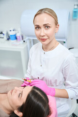 Obraz na płótnie Canvas Professional beautician on cosmetology procedure for skin with female