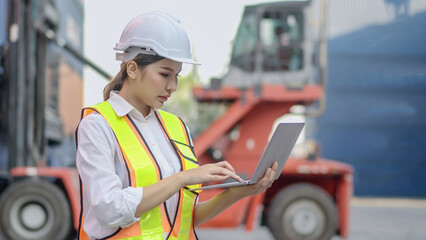 Asian engineer woman working in container port terminal. Young businesswoman process order and...
