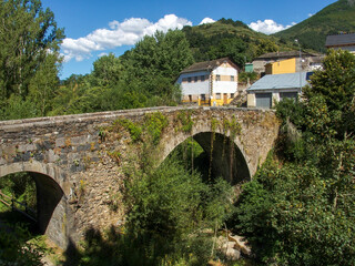 Fototapeta na wymiar Royal Bridge from 1709 in the town of Rioscuro de Laciana. Villablino, Castile and Leon, Spain.<