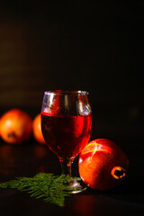 ripe pomegranate and glass of wine on black background. Closup