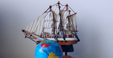 Travel Concept Stock Photo. Blurred Globe In Front Of Wooden Model Of Old Ship