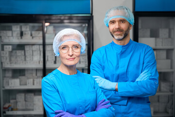 Colleagues laboratory assistants in blue uniforms stand in the laboratory