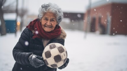 A woman posing with a soccer ball in the snow