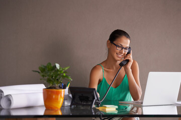 Phone call, remote work and landline with receptionist woman in office for communication or reception. Laptop, smile and happy young woman answering telephone in small business or startup workplace