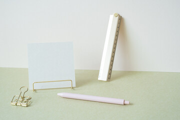 Blank memopad with gold metallic holder, ruler, pen, clip on desk. white ivory background....