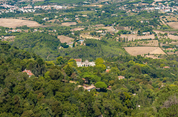 Fototapeta na wymiar Aerial drone view of the Seteais Palace in Sintra, Portugal, with the entire green mountain range around and luxury chalets.