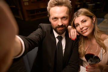 Elegant couple taking a selfie in a restaurant