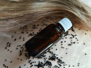 Fototapeta premium Olej z czarnuszki na włosy w szklanej butelce