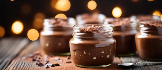 Fotobehang Indulgent Treat: Glass Jar of Decadent Chocolate Pudding with Shiny Spoon for a Tempting Dessert © vxnaghiyev