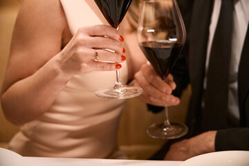 Couple in evening dresses with glasses of red wine