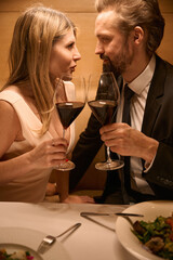 Middle-aged couple in a restaurant with glasses of red wine