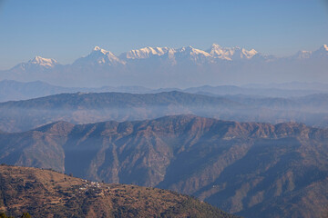 The distant snowcapped mountains of the Himalayas from the foothills near Nainital, Uttarakhand, India.