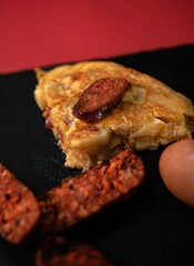 Spanish potato omelette on a black slate tray, with potato, eggs and chorizo