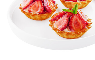 Tartlets with custard, strawberries and mint served on white plate