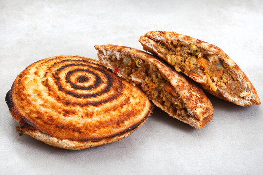 Jaffle, an old school toasted sandwich, filled with savory mince. Grey backdrop, copy space