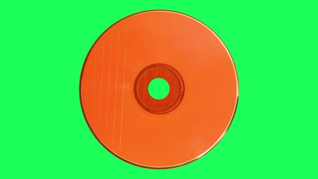 Orange CD or DVD spinning on the green screen. Top view.