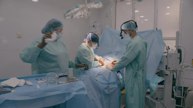 Medical team men doctors physicians surgeons nurse processing surgical operation in hospital clinic emergency medicine heart stomach surgery cut out appendicitis cancer tumor disease health patient