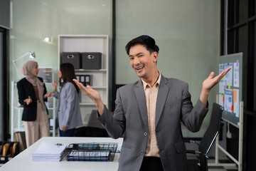 Happy young Asian man presenting or showing open hand palm, happy working.