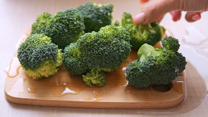 Another piece of broccoli is placed on cutting boar showing off vibrant green. Broccoli rest ready for preparatio offering its wholesome goodness Explore versatility of broccoli for culinary creations