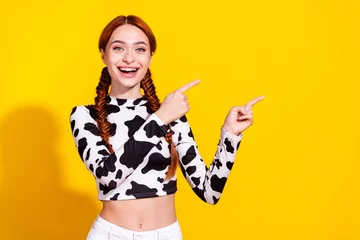 Foto op Canvas Photo of impressed excited woman wear cow skin top pointing two fingers empty space isolated yellow color background © deagreez