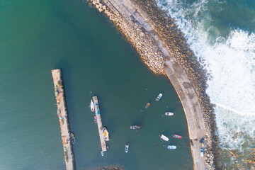 drone aerial top view of a breakwater protecting a fishing port