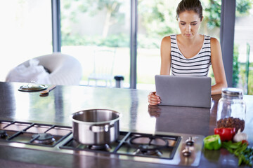 Woman, kitchen and laptop for food idea, female person and home on internet. Google it, browsing...