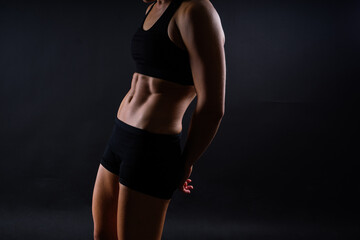 Fototapeta premium Fitness woman showing abs and flat belly, isolated. Athletic female shaped abdominal