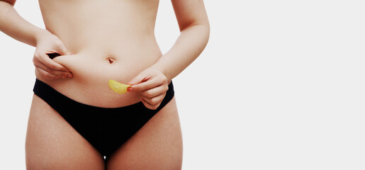 Fototapeta na wymiar Overweight female body. Beautiful woman holding junk food in her hand. Body care, stretch marks and cellulite. Medicine and Cosmetology, Liposuction and Sports