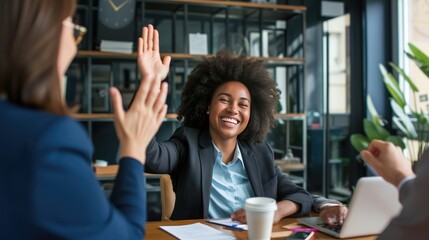 Businesswoman giving a high five to a colleague in meeting 