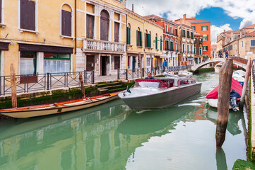 Boats and gondolas at the quayside, along a canal, in Venice in Veneto, Italy - obrazy, fototapety, plakaty
