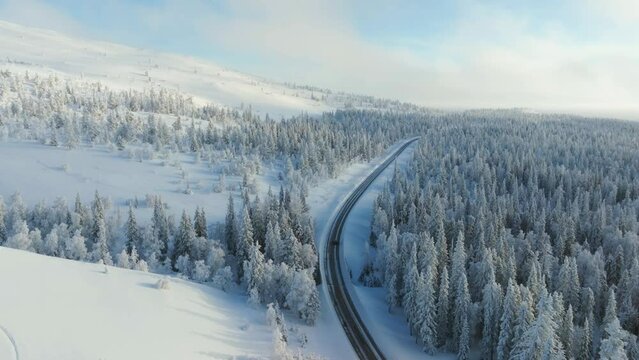 Drone tracking a car driving on the Yllas scenic road, winter day in Finland