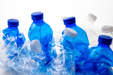 Plastic bottles, blue and transparent, crushed. Waste and plastic pollution, plastic recycling. 
