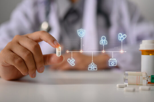 Doctor holding capsule pill in hand with icon medical network. Pharmaceutical and health care concept