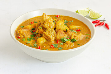 Thai Chicken Curry in a Bowl with Cilantro and Lemon on White Background Close Up Photo
