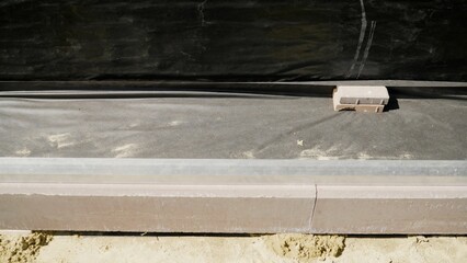 Red curb stone along the path. Installation of curb stones in a private house.